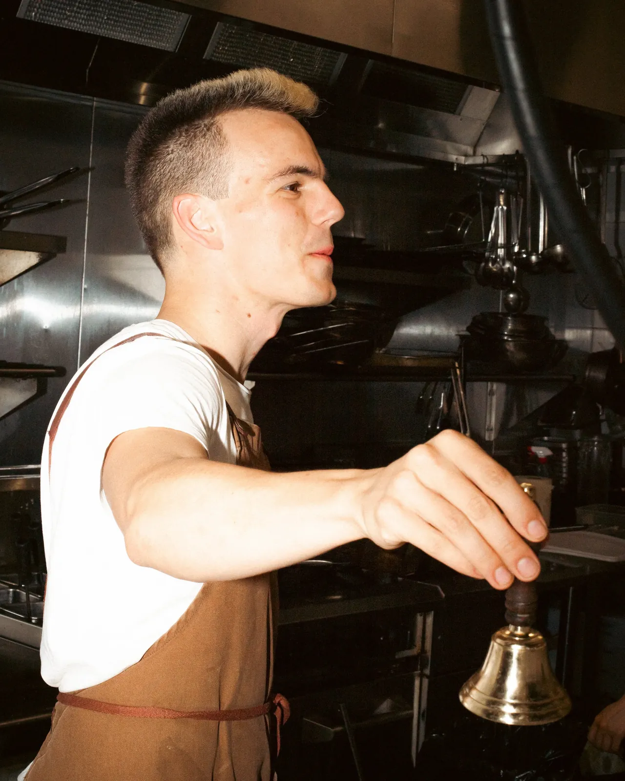 Alex ringing the service bell in the kitchen