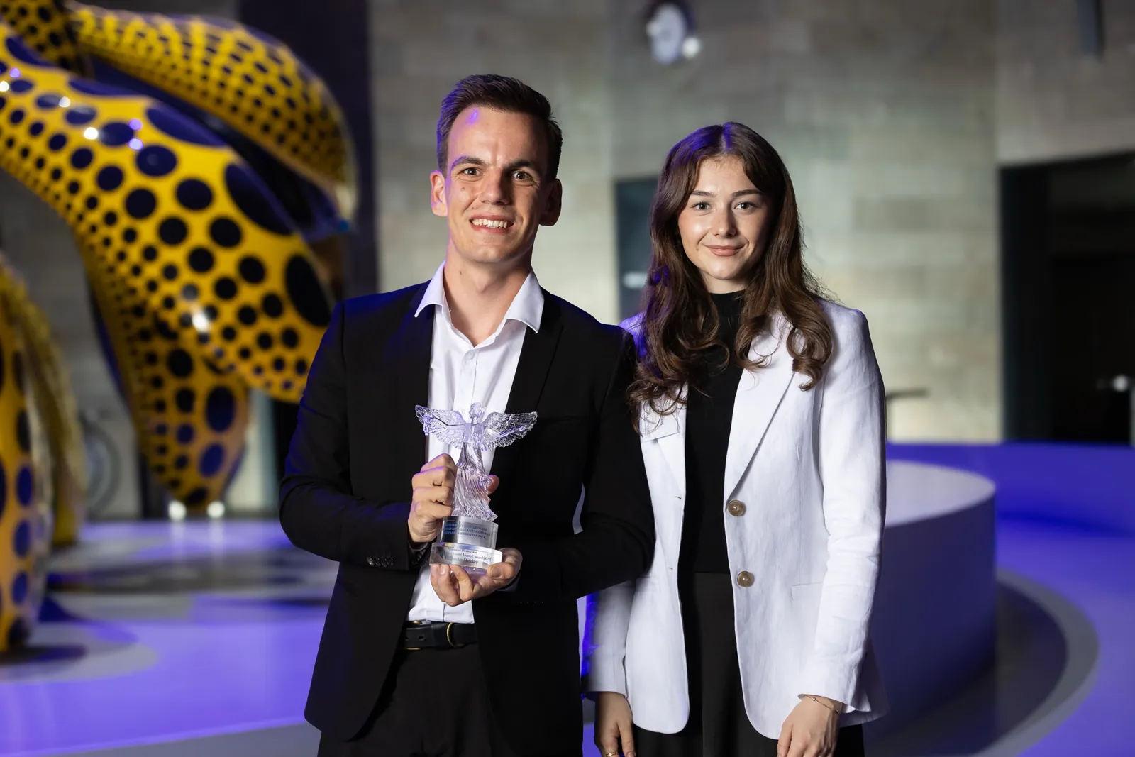 Alex and a guest with the award at the 2026 University of Melbourne Alumni of Distinction dinner