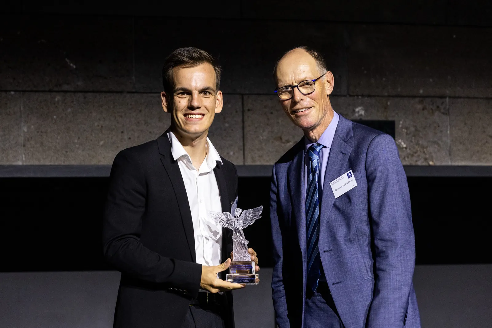 Alex being presented with the 2026 University of Melbourne Alumni of Distinction award